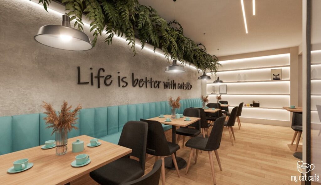 Visão do MyCatCafé, um espaço acolhedor que combina uma cafeteria com uma experiência única para amantes de gatos. O ambiente aconchegante é decorado com detalhes rústicos e conta com gatinhos que interagem com os visitantes. O atendimento é atencioso, e o cardápio oferece delícias como cafés e croissants, tudo a preços justos. O café não apenas proporciona momentos especiais, mas também apoia a adoção de gatos, tornando a visita ainda mais gratificante. Ideal para quem busca um lugar que aquece o coração!